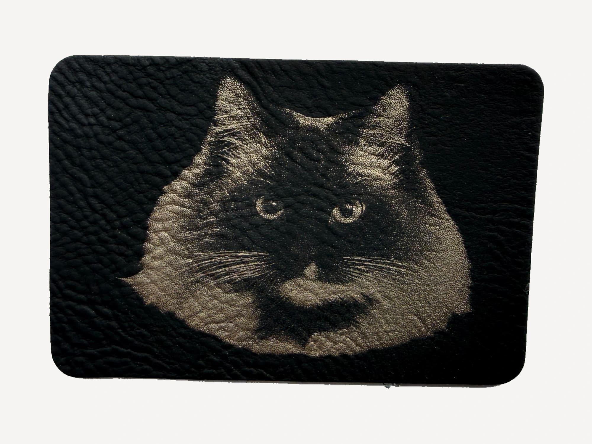 A cat portrait engraved in gold on a black patch