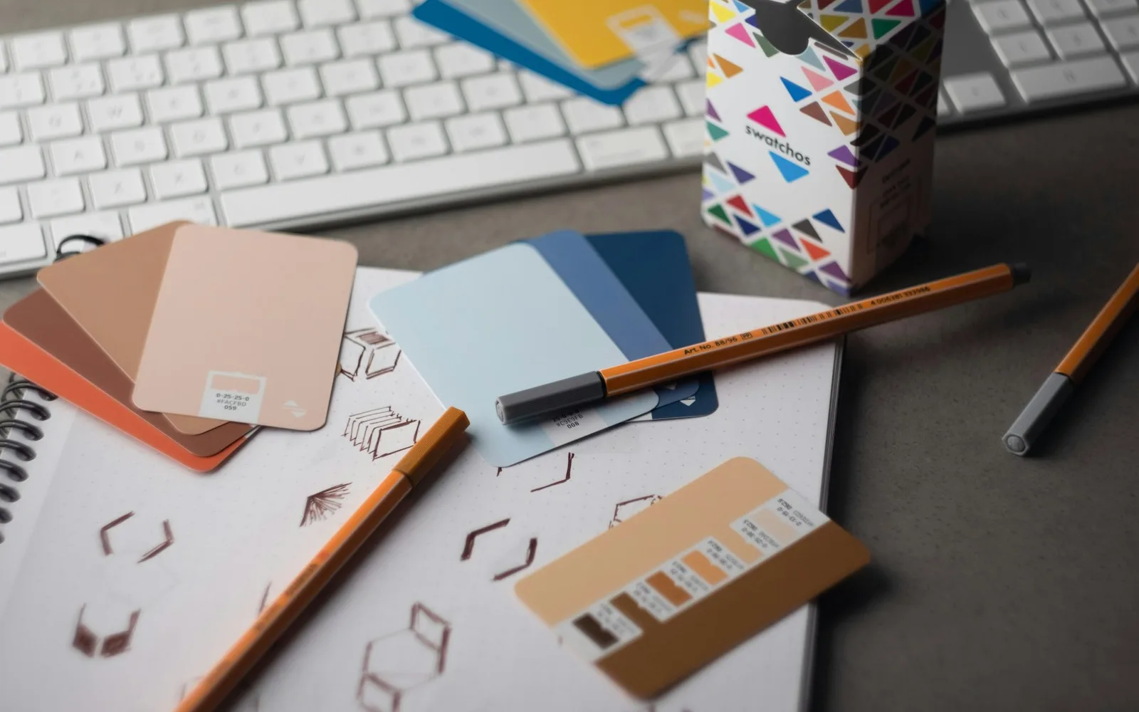 Ontwerptafel met kleurstalen, schetsen en digitaal artwork