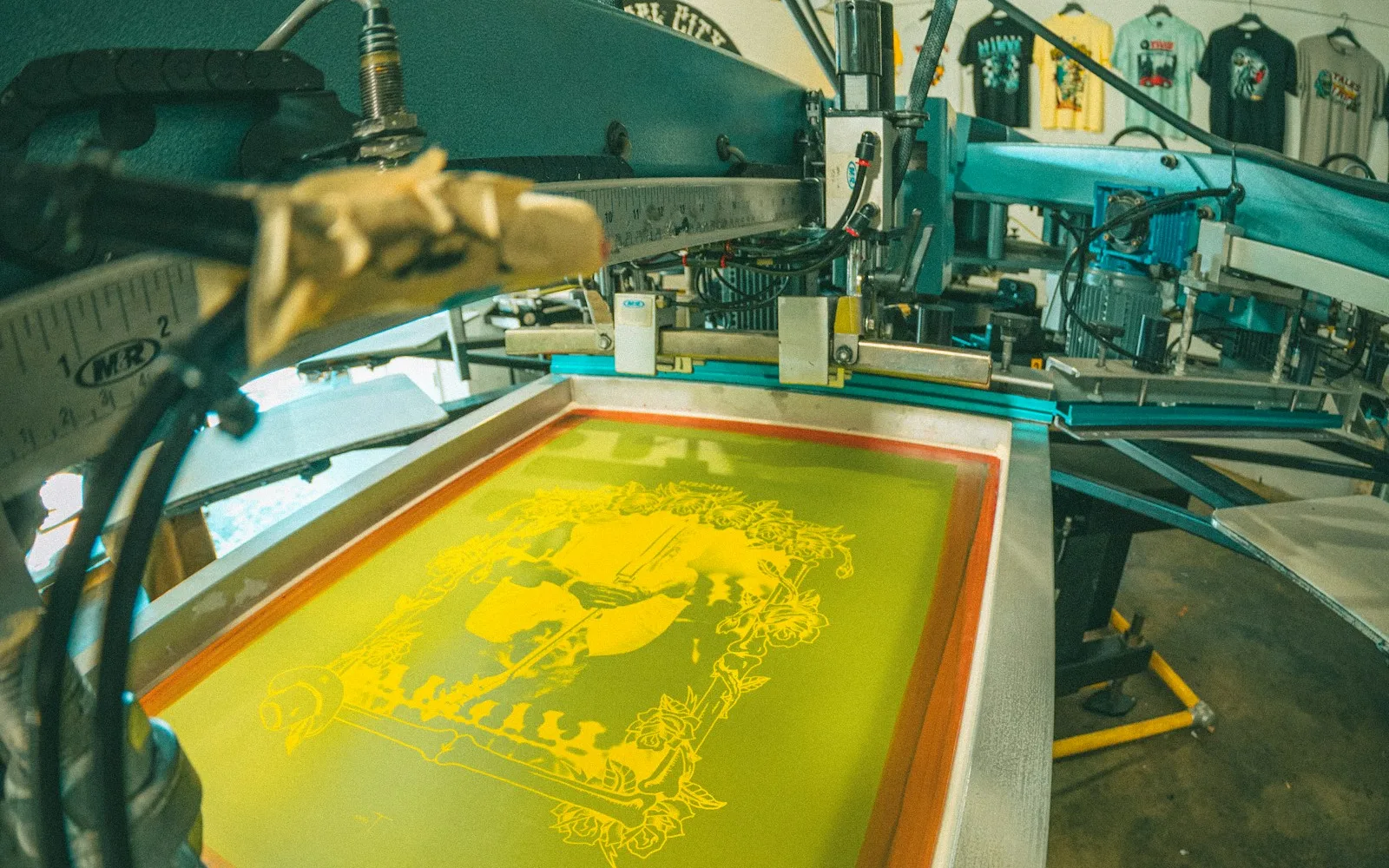 Zeefdrukraam met gele inkt in een professionele drukwerkplaats